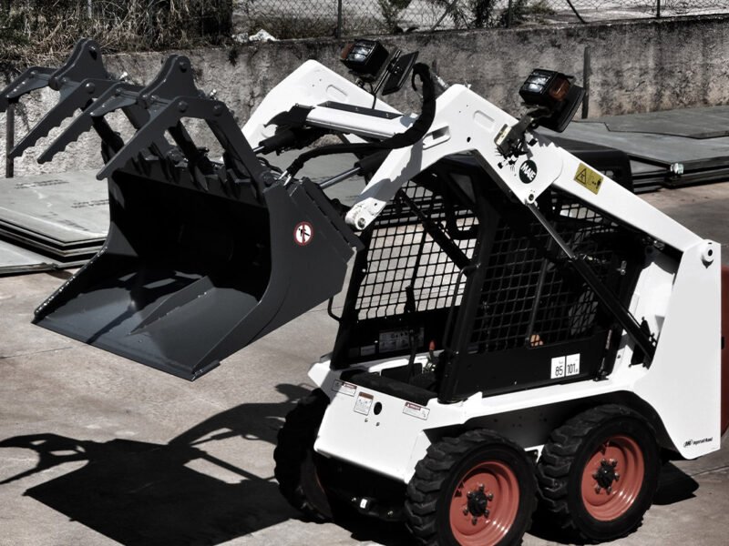 Slidstūmējiekrāvēji ar greifera kausa stiprinājumu